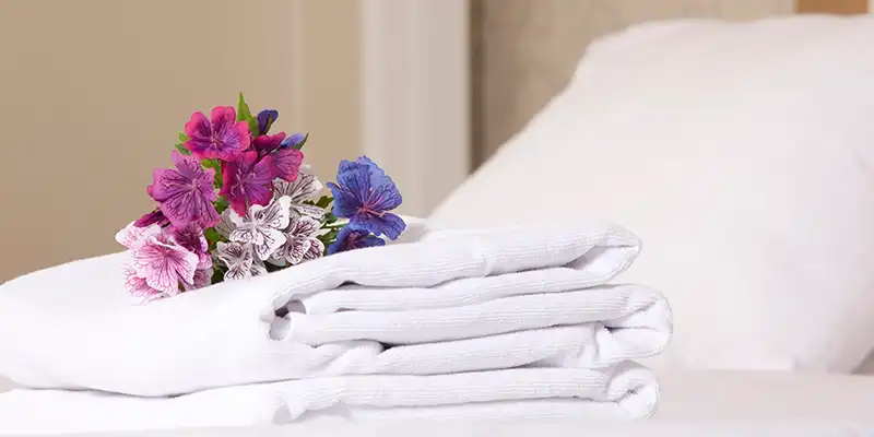 Toallas sobre una cama de hotel y flores