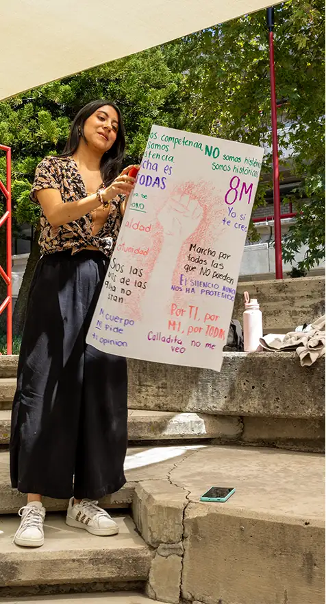 Alumna con cartel de protesta